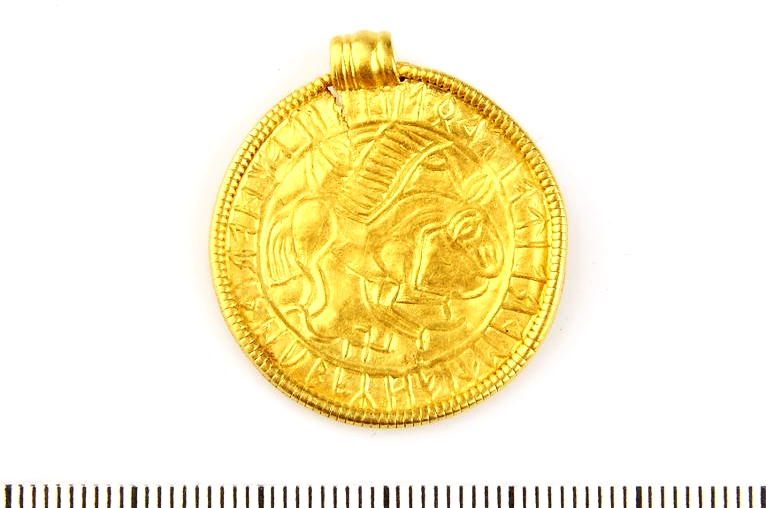 Rutosalainen kansainvaellusaikainen kultabrakteaatti, jossa eläinhahmon alapuolella on hakaristiä muistuttava kuvio. Kuva: Sanna Stahre/SHMM. Kringla.nu.