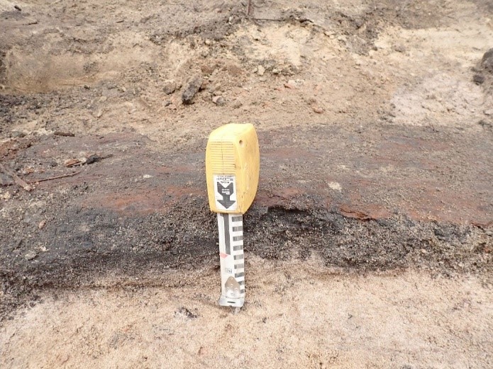 Kuva 16. Pohjamaan pinnalla oleva palomaa alkaa välittömästi puurakenteen alta. Mikroliitti