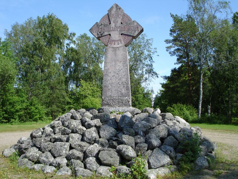 Kuvassa on aukio, jonka keskellä on Korsholman linnan kivinen muistomerkki: kivikasa, jonka keskeltä kohoaa risti