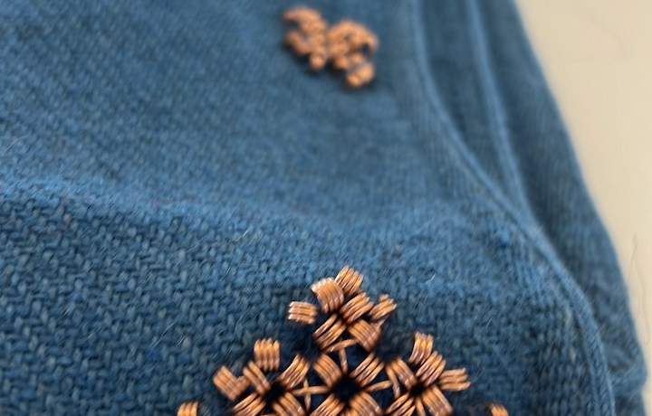 Pronssispiraalikoristeista viitan reunaa.