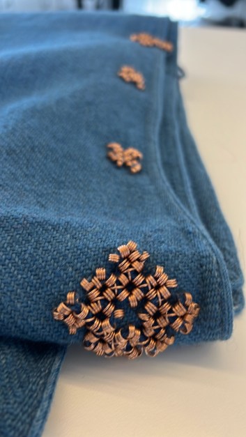 Pronssispiraalikoristeista viitan reunaa.